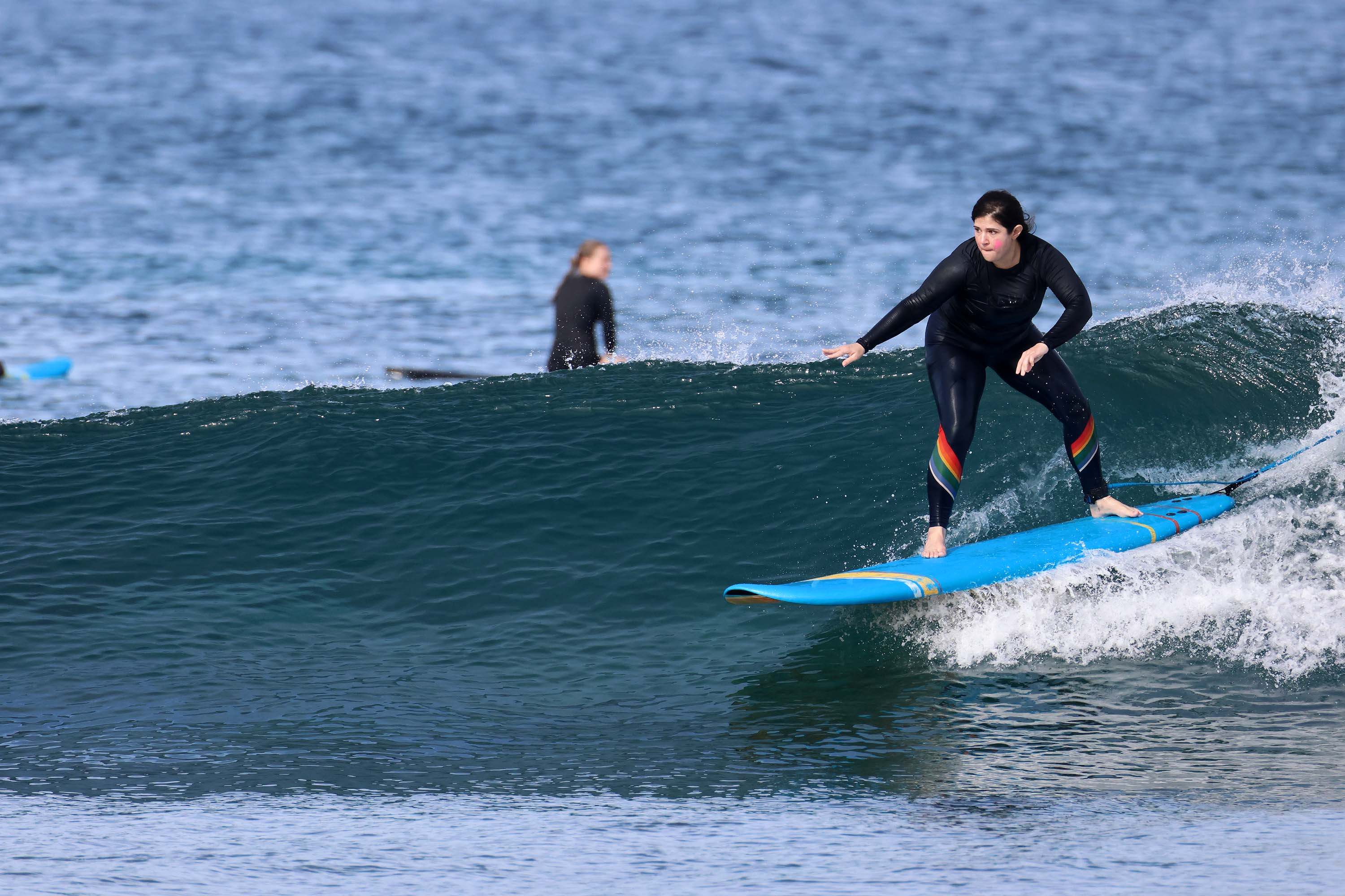 Surfer riding a longboard on a clean wave